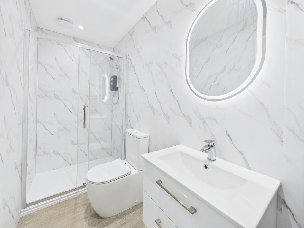 Modern bathroom featuring a glass-enclosed show...