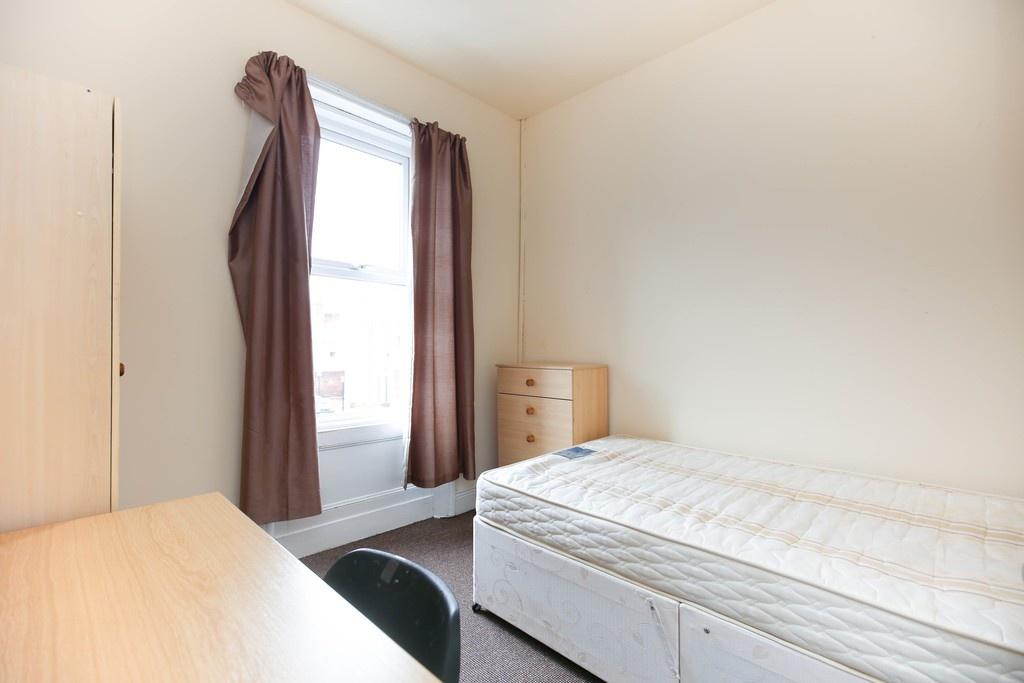 Bright, simply furnished bedroom with a single ...