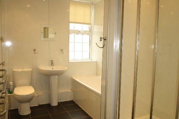Bright, well-maintained bathroom with a bathtub...