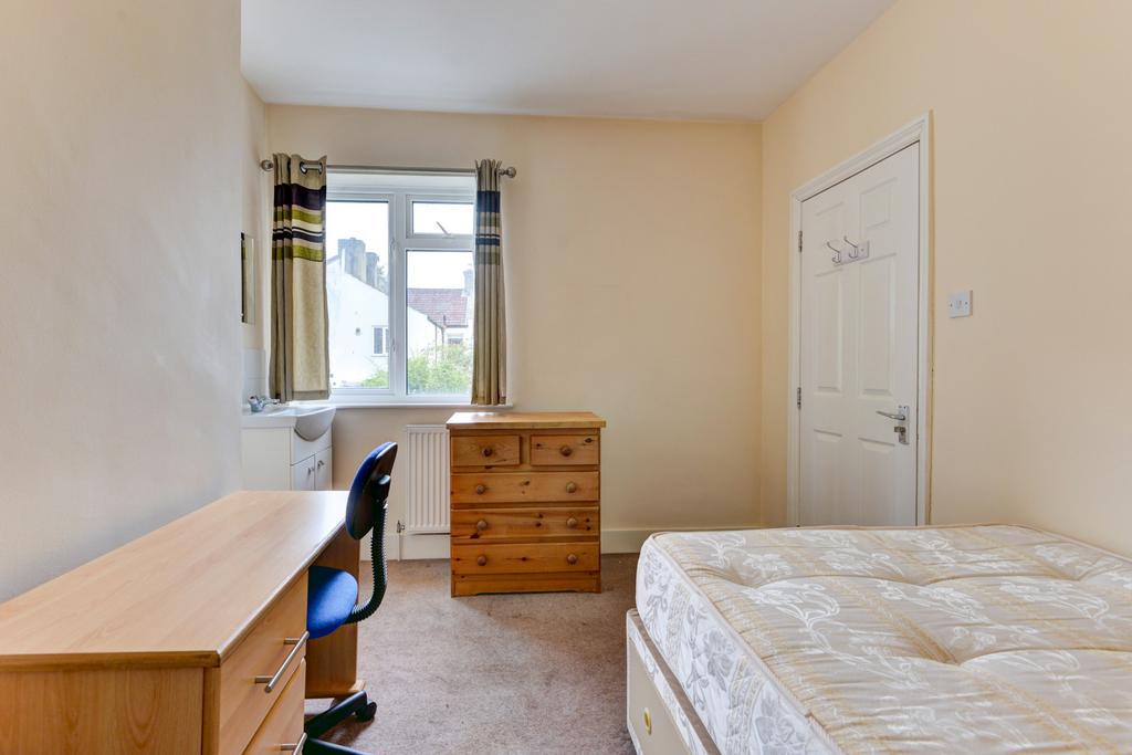 Bright, simply furnished bedroom with a large w...