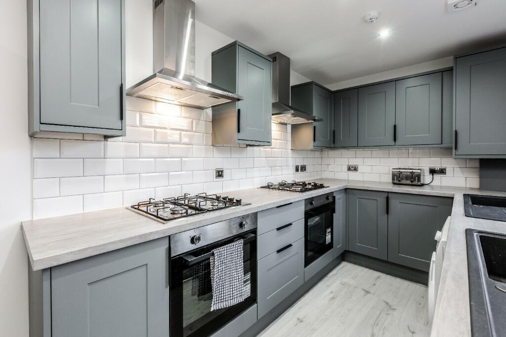 A modern, spacious kitchen featuring light blue...