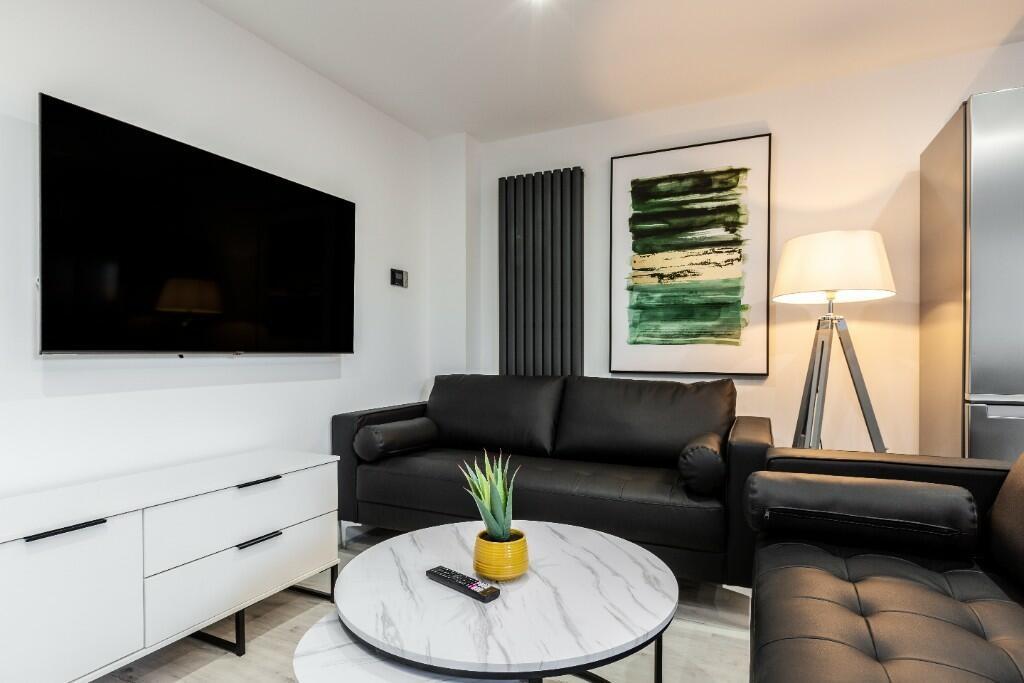 A modern, well-lit living room featuring a slee...