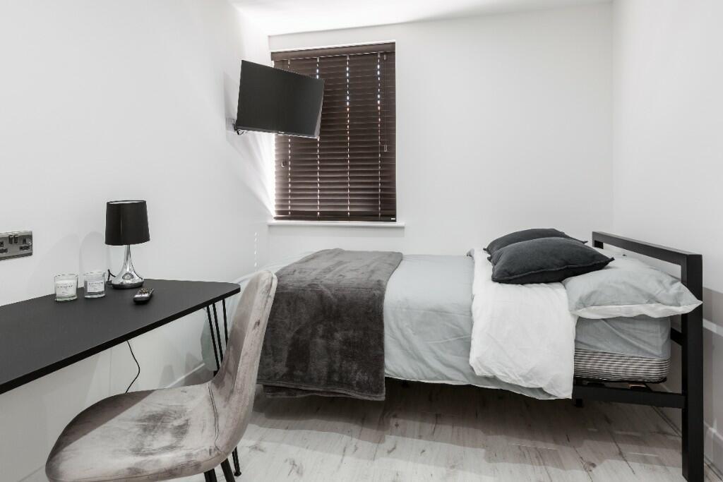 A well-presented bedroom featuring a comfortabl...