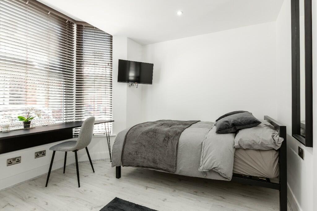 A bright and modern bedroom featuring a comfort...