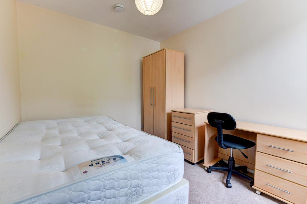 Neat, simply furnished bedroom with a comfortab...