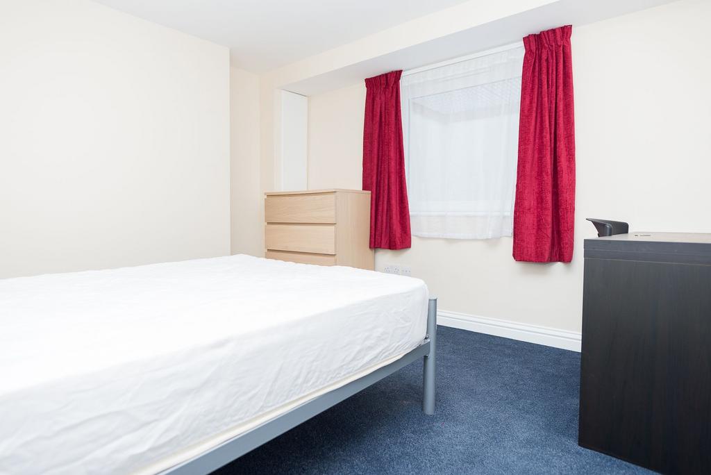 Bright, simply furnished bedroom with a double-...
