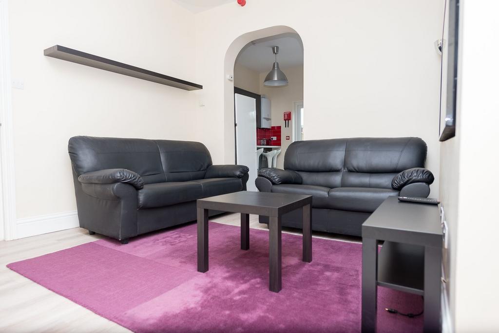 Bright, modern lounge with two black leather so...