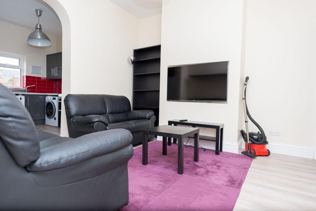 Bright, modern living area with black leather s...