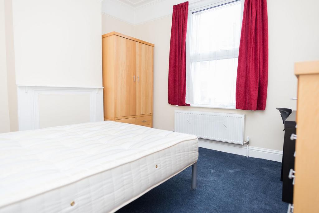 Bright, neutrally decorated double bedroom with...