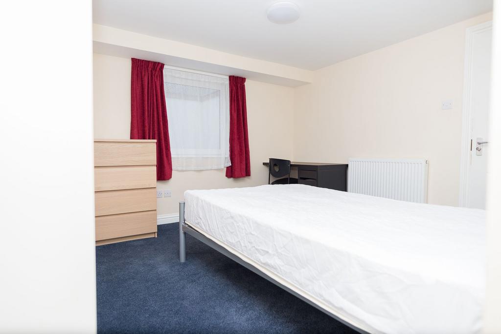 Bright, simply furnished bedroom with a double-...