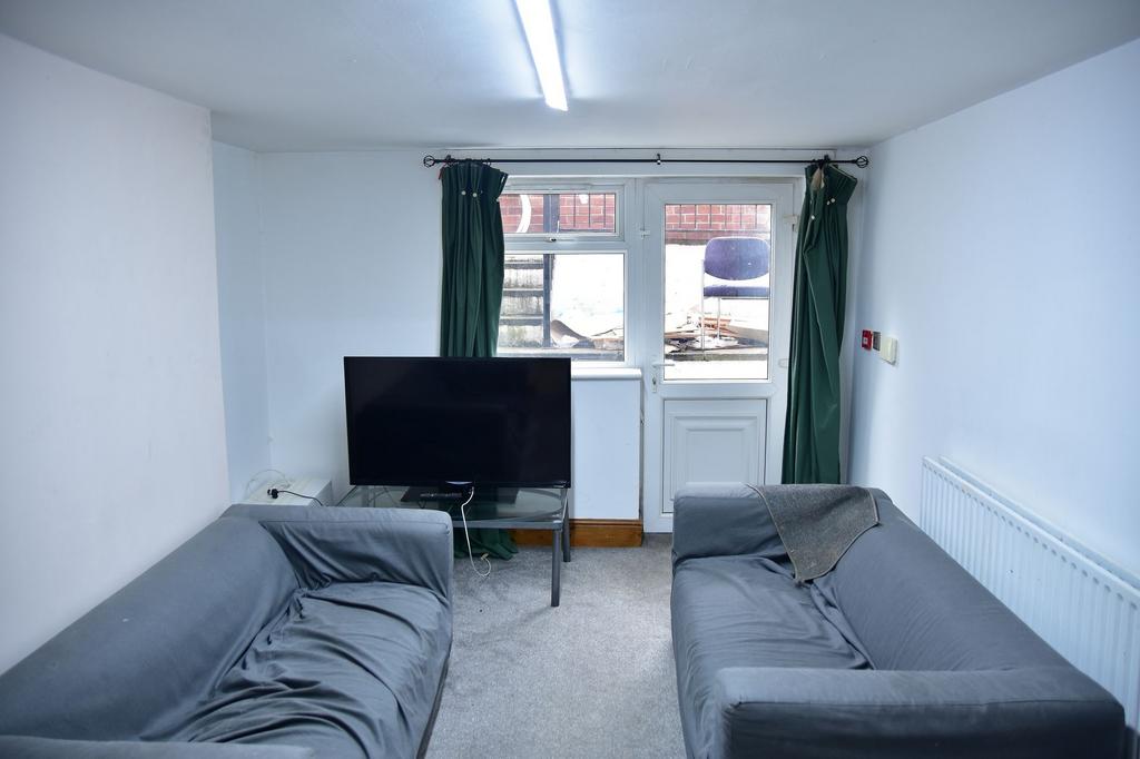 A compact living room featuring two sofas, a TV...