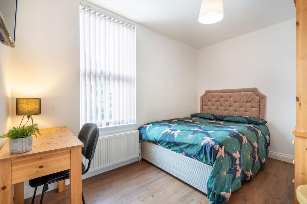 A cozy single bedroom featuring a comfortable b...
