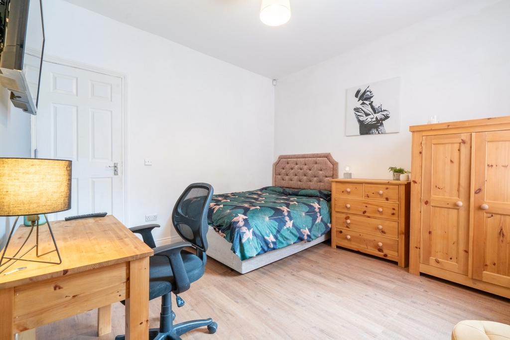 A cozy single bedroom featuring a comfortable b...