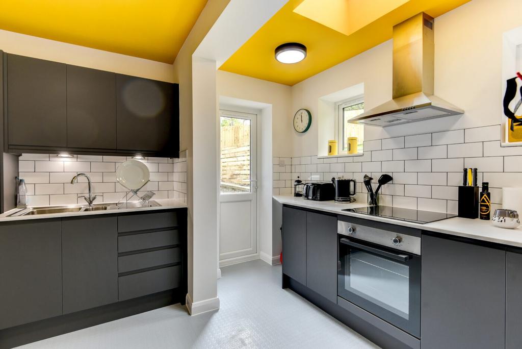 Bright modern kitchen with charcoal cabinets, w...