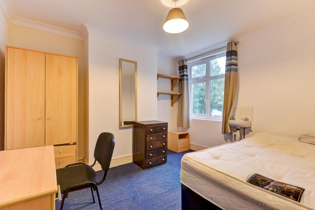 Bright, neatly furnished bedroom with a large w...