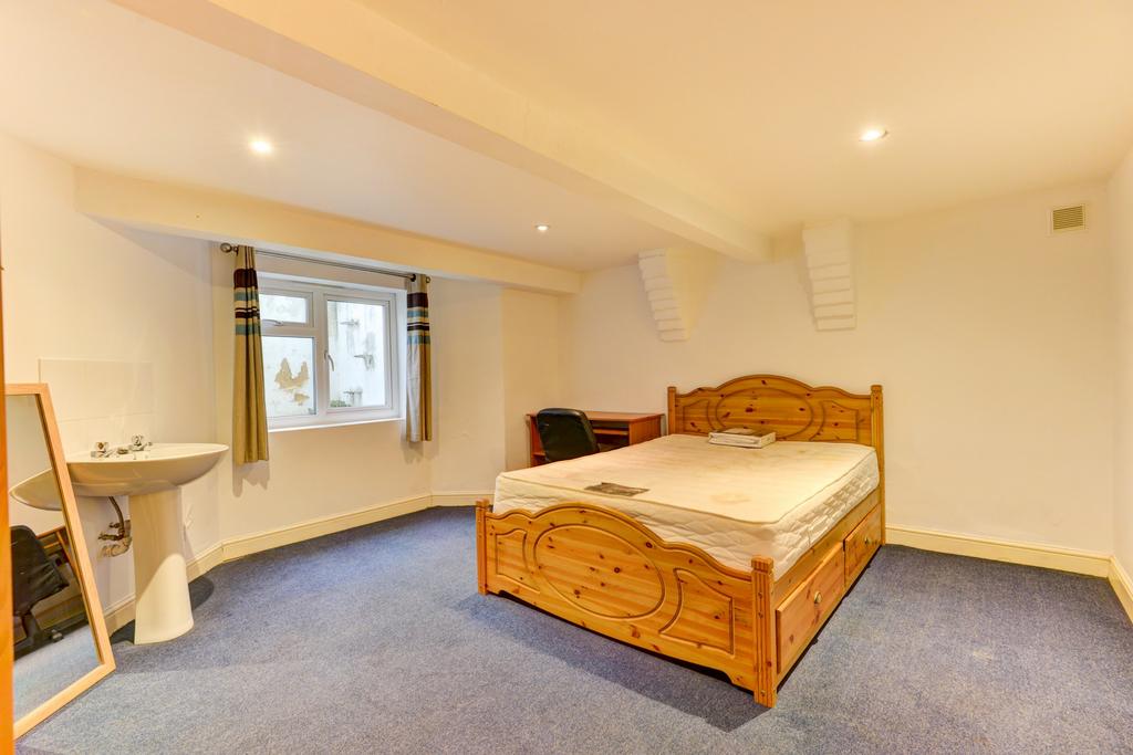 Bright, simply furnished bedroom with a wooden ...