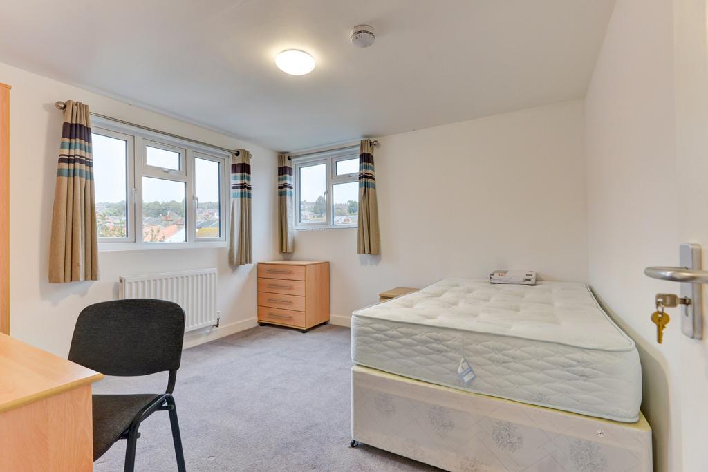 Bright, simply furnished bedroom with a single ...