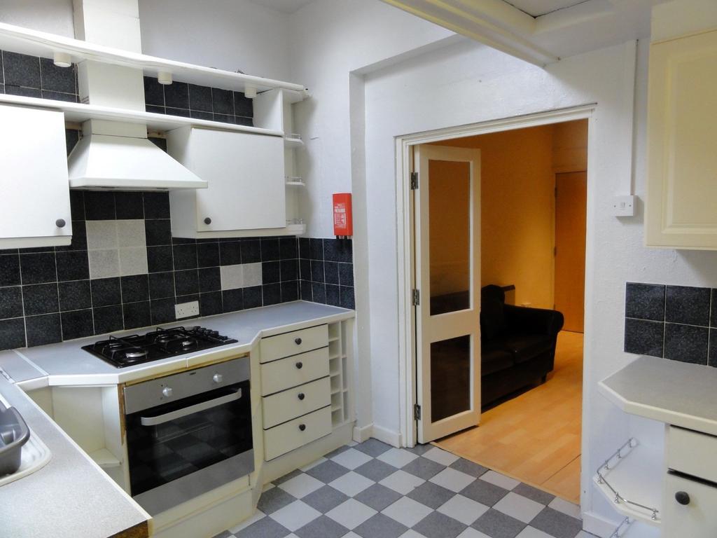 A well-maintained kitchen with black tiled back...