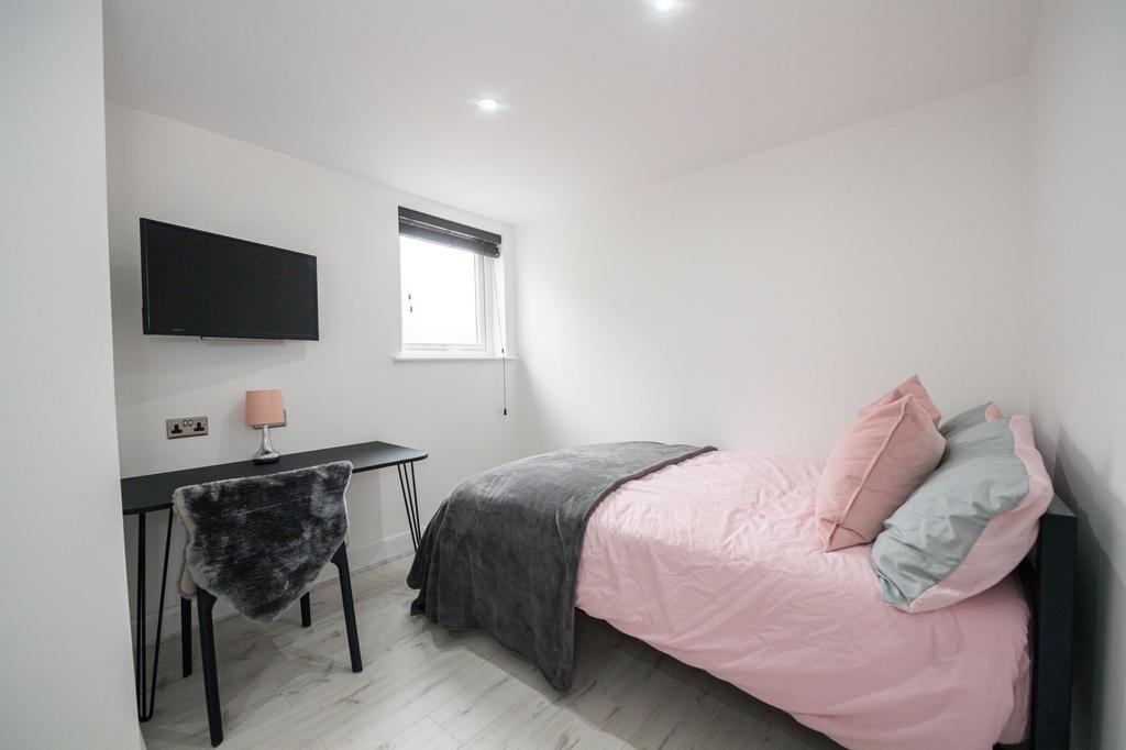 Bright and modern bedroom featuring a comfortab...