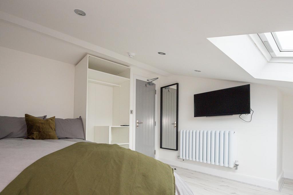 Bright and spacious master bedroom with a comfo...