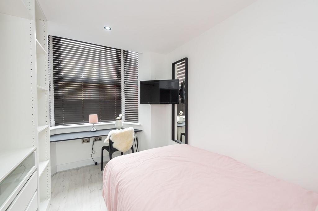 A bright, modern bedroom featuring a comfortabl...
