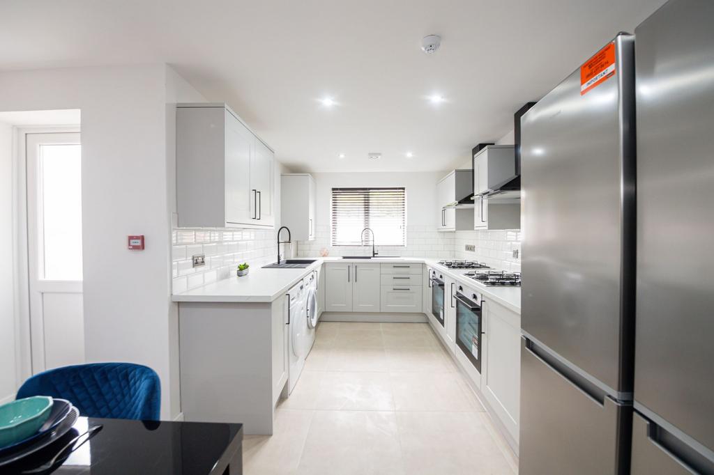 Modern and bright kitchen featuring white cabin...