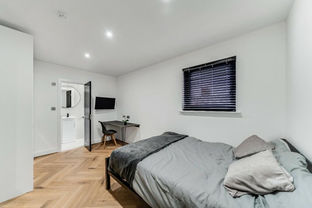 A modern, well-lit bedroom featuring a double b...