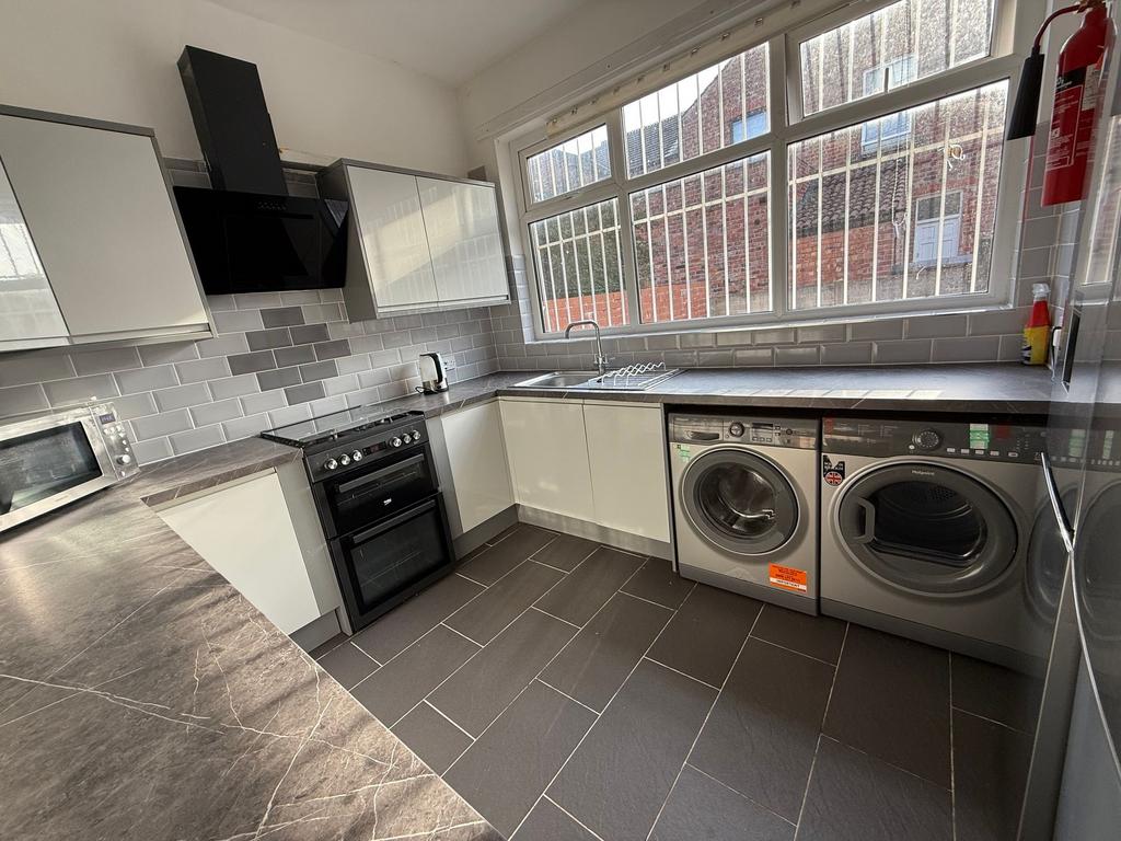 Bright, modern kitchen with sleek grey tiled fl...