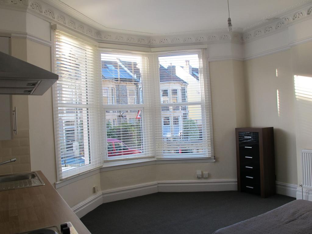 Bright open-plan living area with a large bay w...