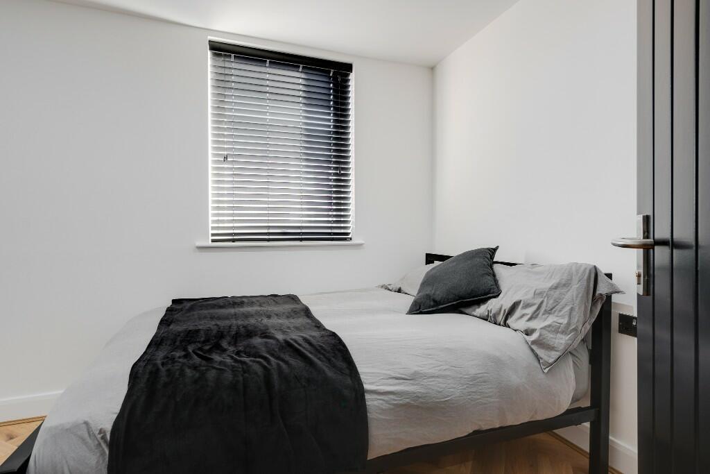 A bright and tidy master bedroom with modern de...