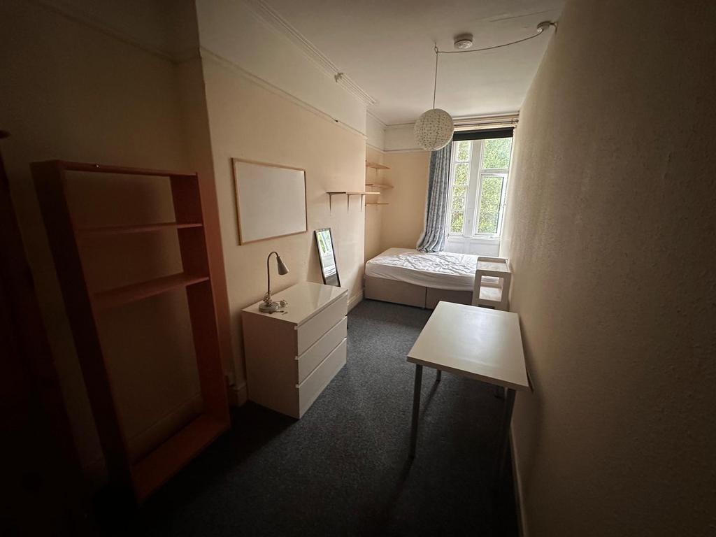Bright single bedroom with a window at the far ...
