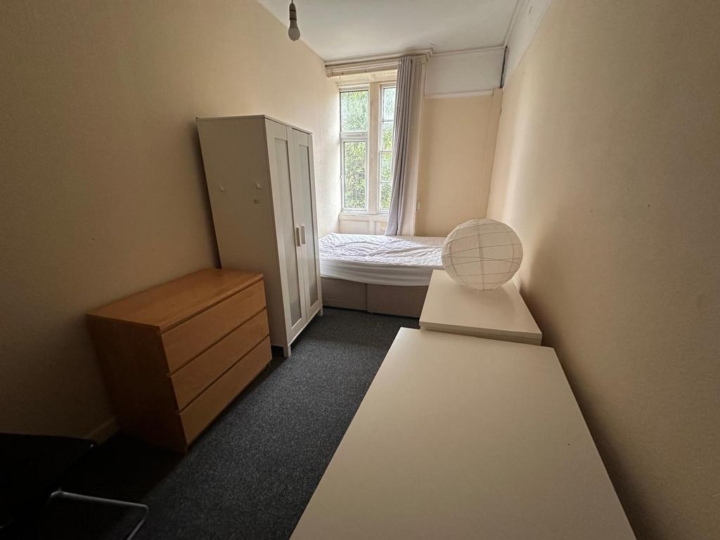 Neat, simply furnished bedroom with a double-he...
