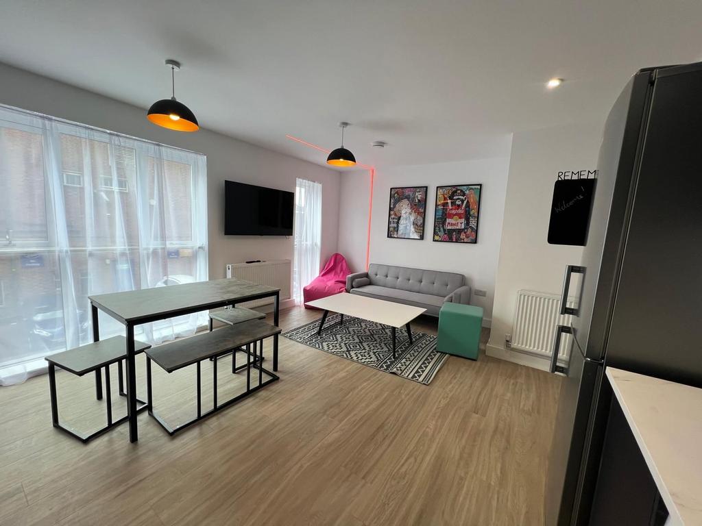 Bright, modern open-plan living area with large...