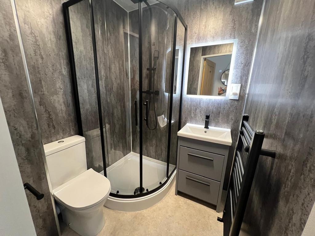 Modern ensuite bathroom with a curved glass sho...