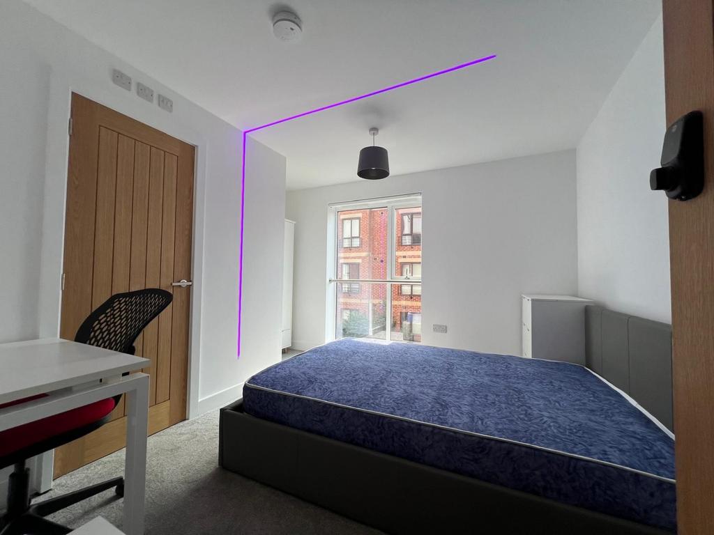 Bright, modern double bedroom with a large wind...