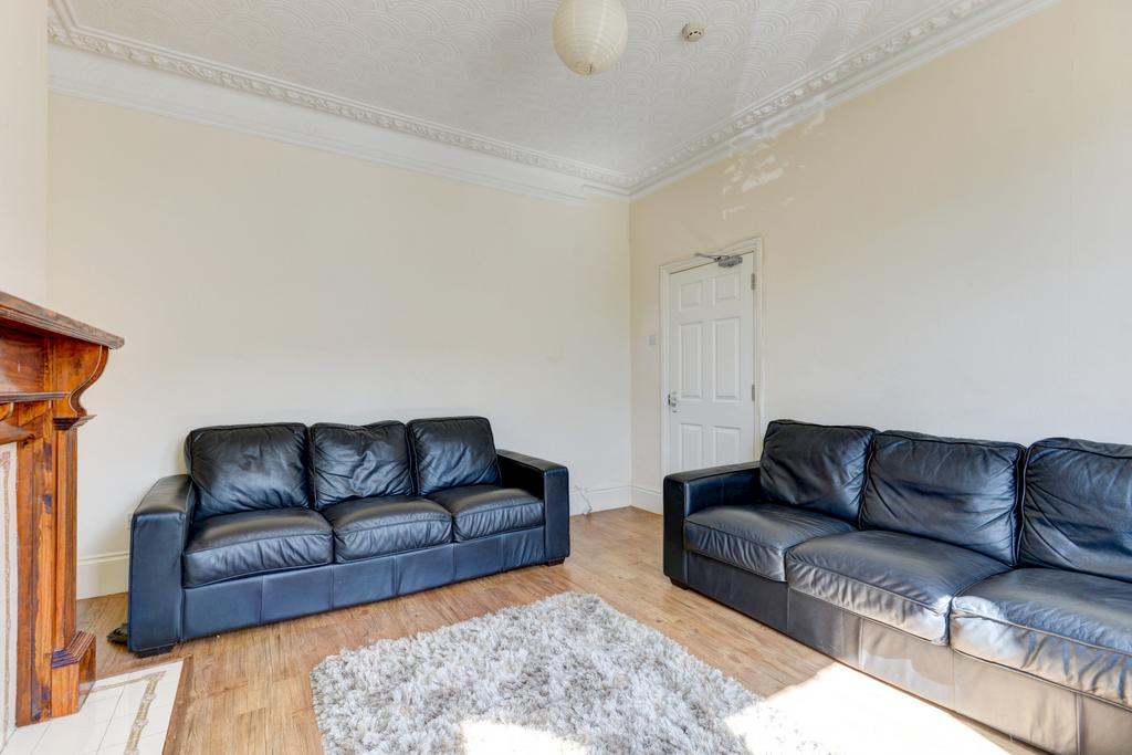 A bright living room featuring two black leathe...