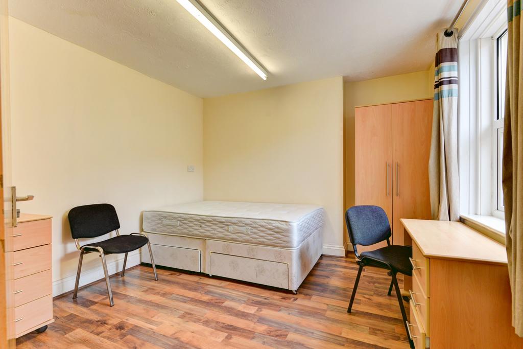 Bright, simply furnished single bedroom with a ...