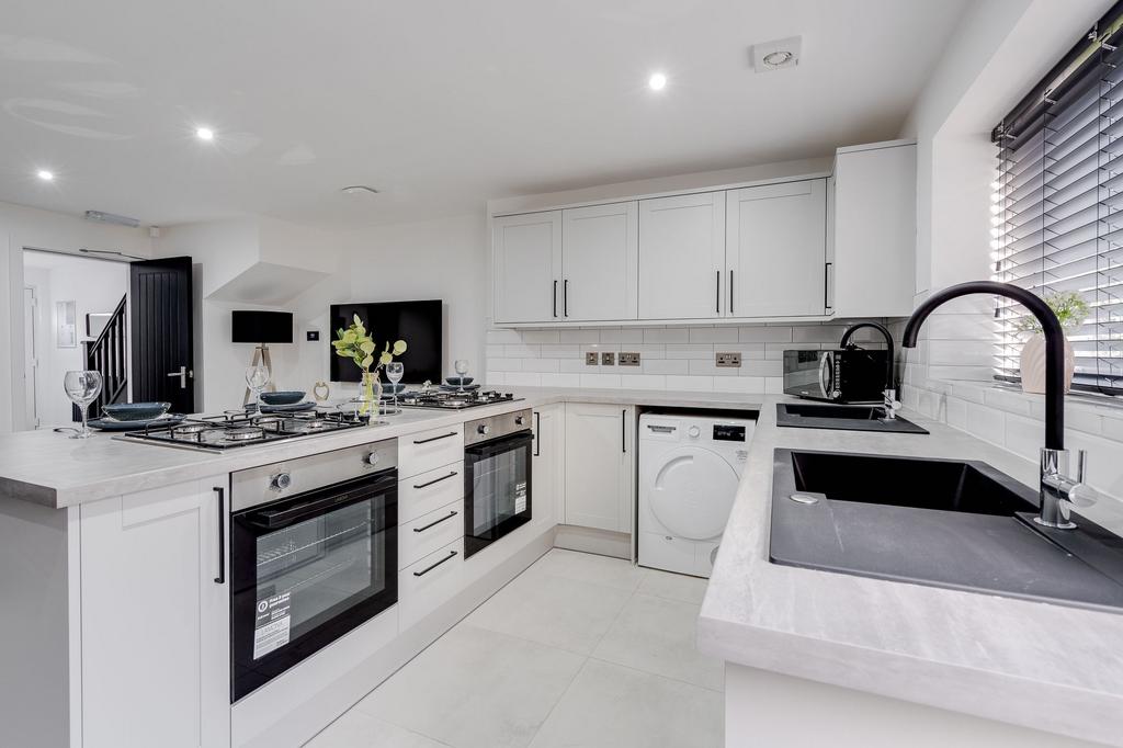 Modern and bright kitchen featuring white cabin...