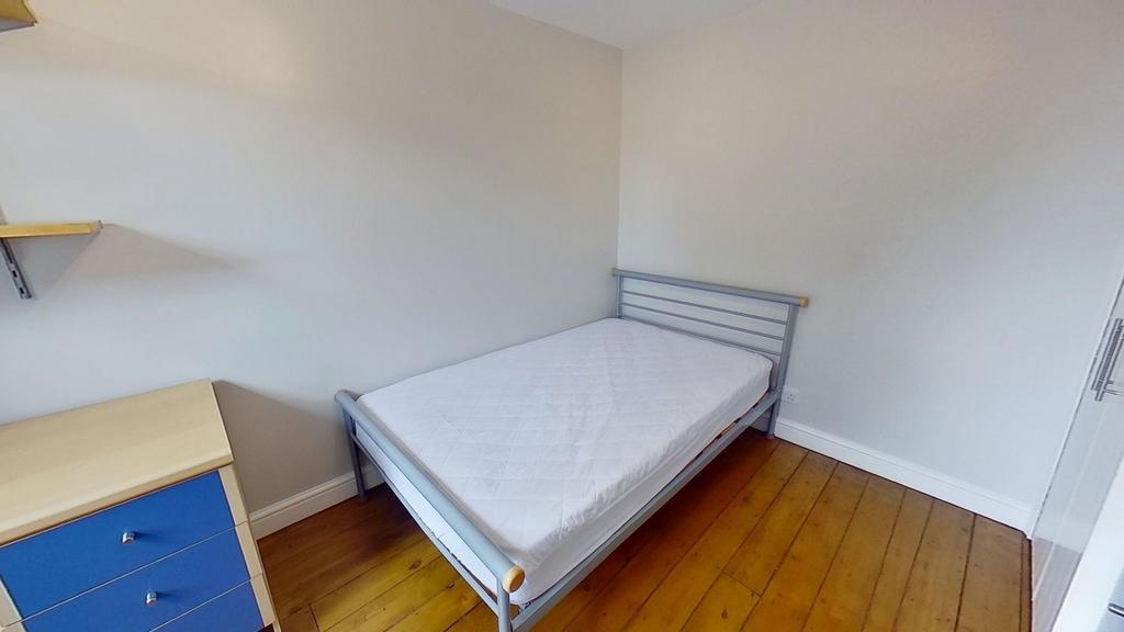 Bright, simply furnished bedroom with a single ...