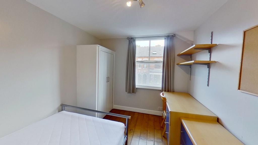 Bright, tidy bedroom with wooden floors, a ward...