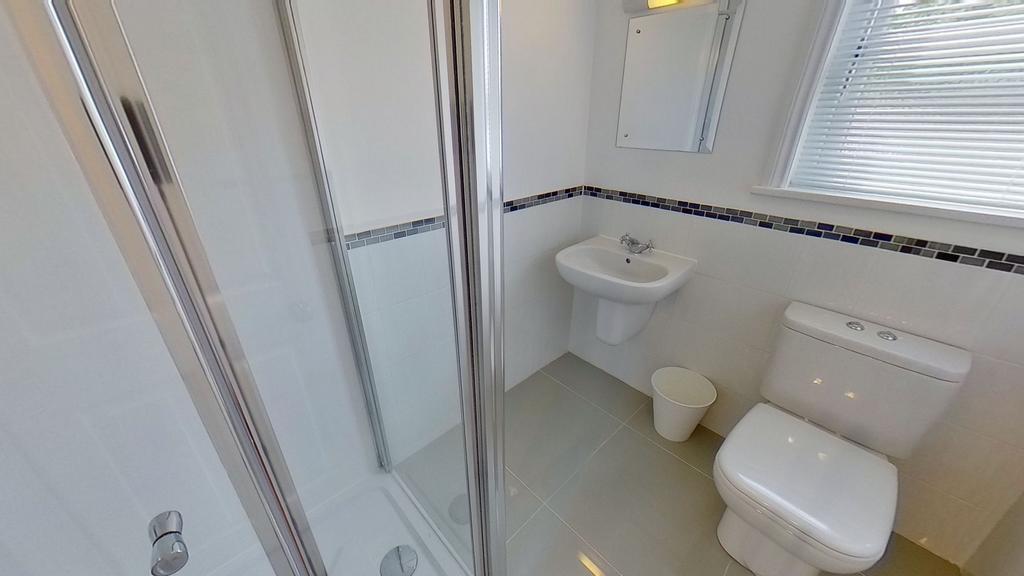 Bright, modern bathroom with a glass shower enc...