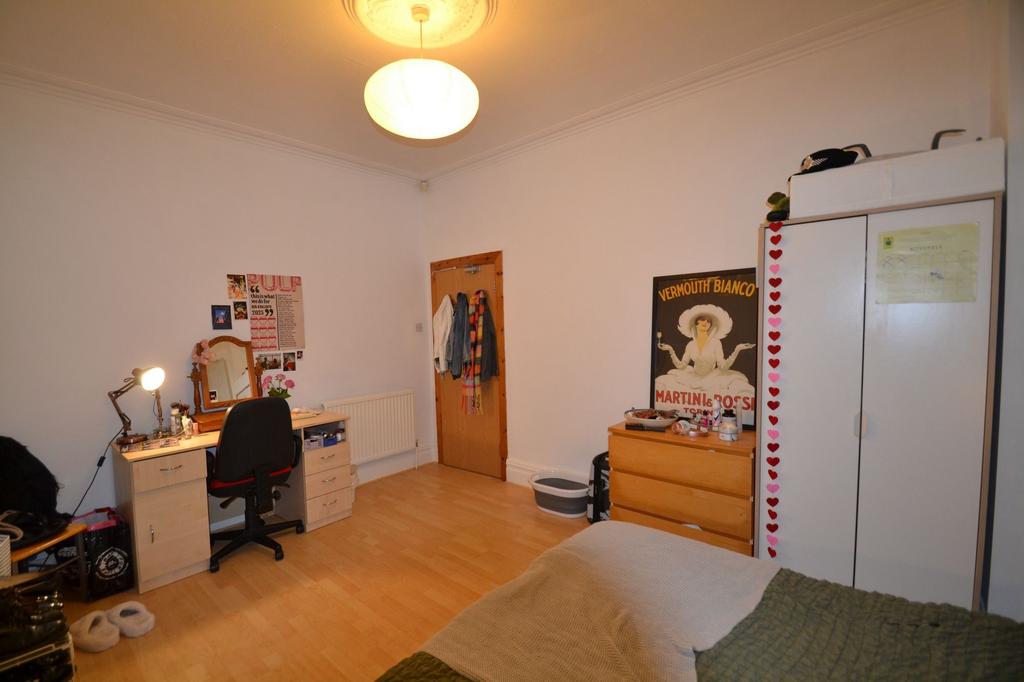A bright and tidy bedroom featuring a comfortab...