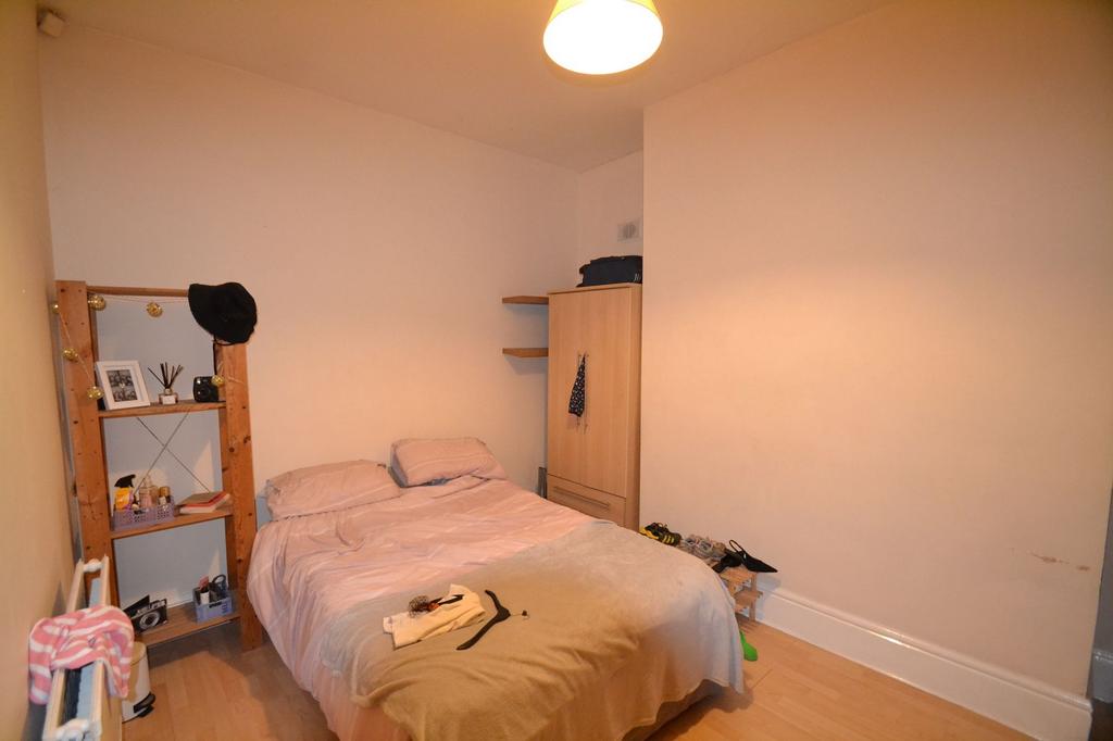 A cozy bedroom with a double bed, featuring sim...