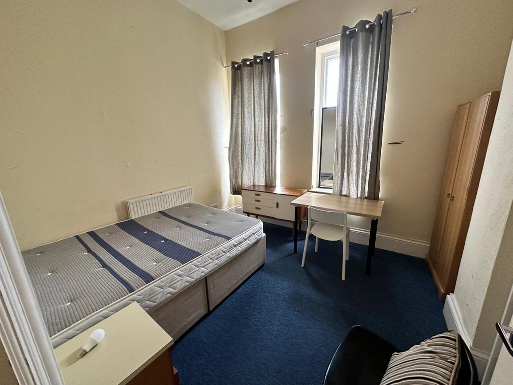 Bright double bedroom with two tall windows, ne...