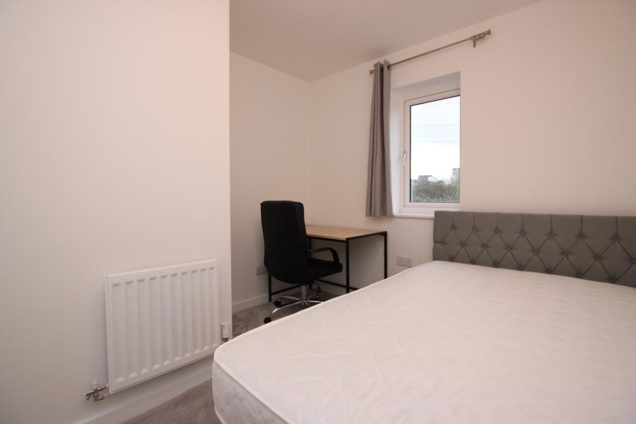 Bright, simply styled bedroom with a comfortabl...