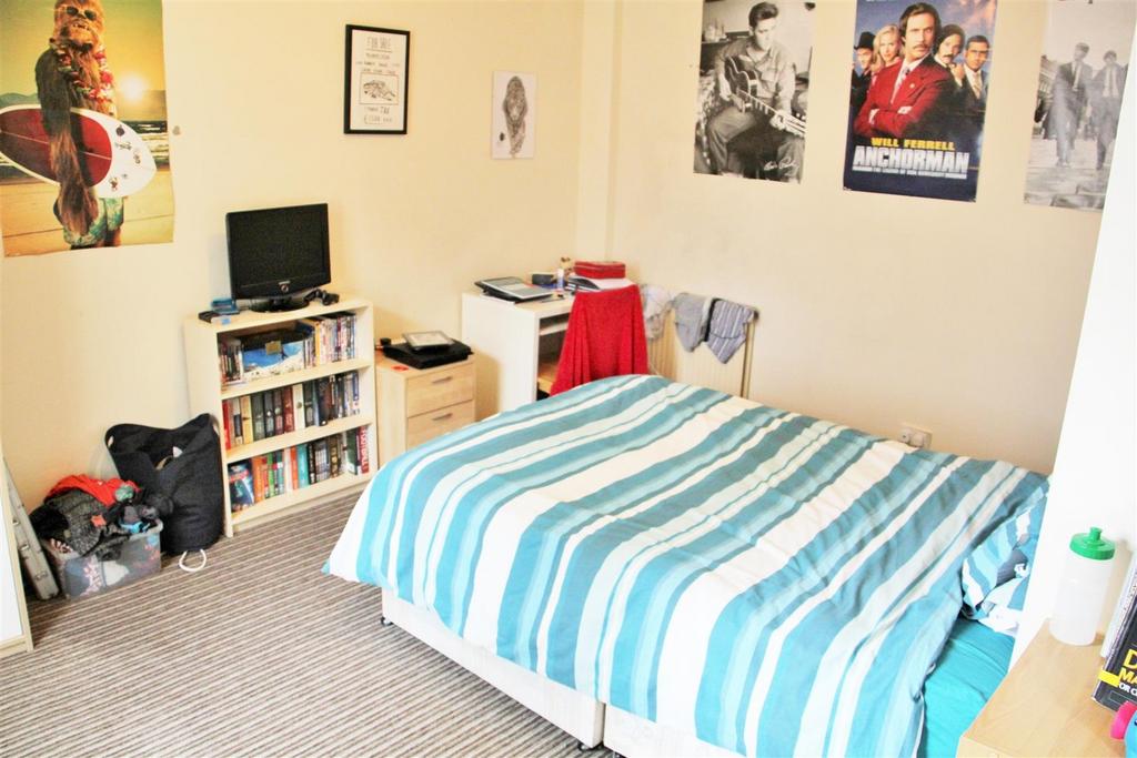 Cozy student bedroom featuring a comfortable be...