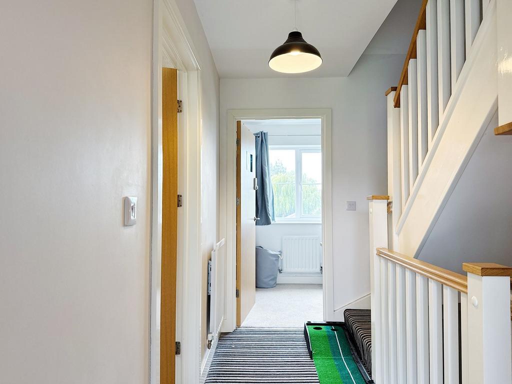 Bright, well-maintained hallway with striped ru...