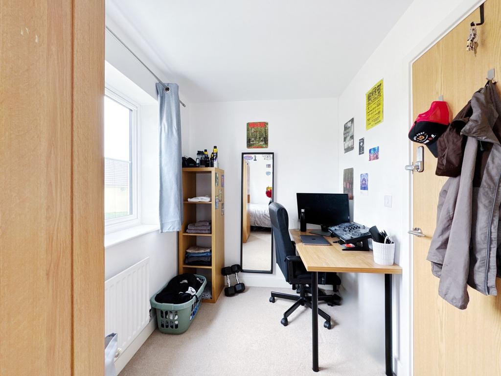 Bright single bedroom with a window-dressed bay...