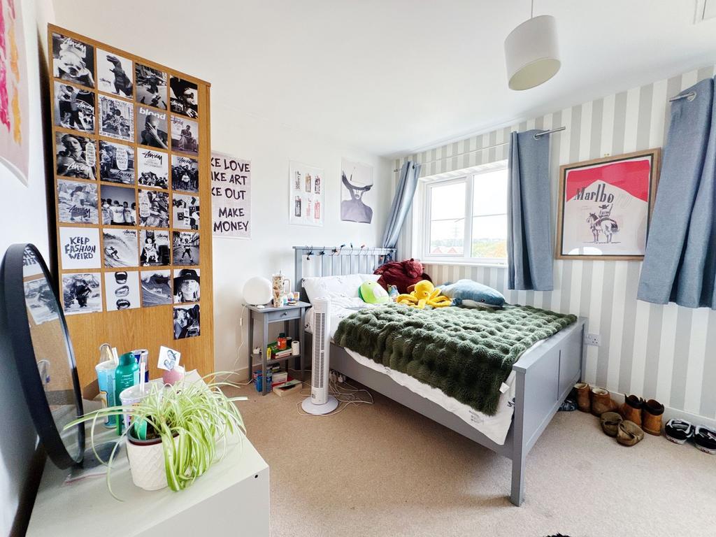 Bright, neatly styled double bedroom with a com...