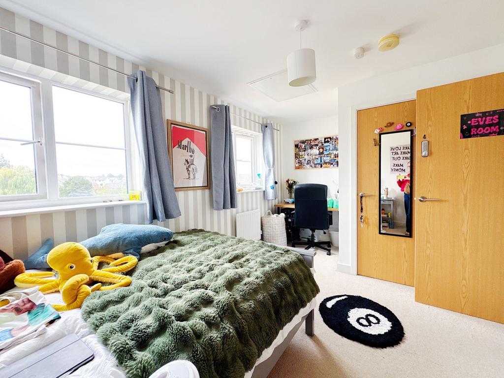 Bright, well-decorated bedroom with large windo...